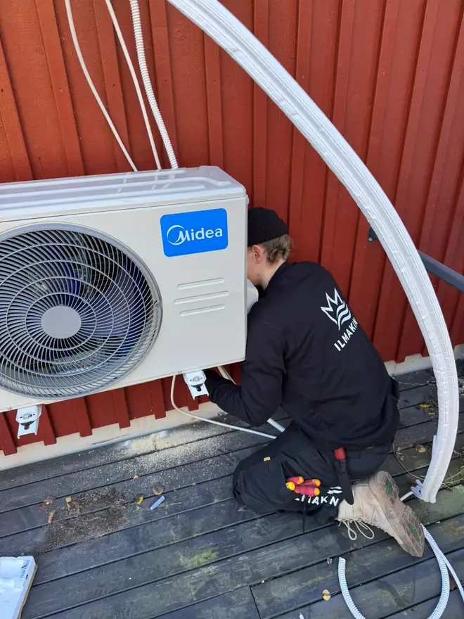 IlmaKingin asentaja asentamassa ilmalämpöpumpun ulkoyksikköä